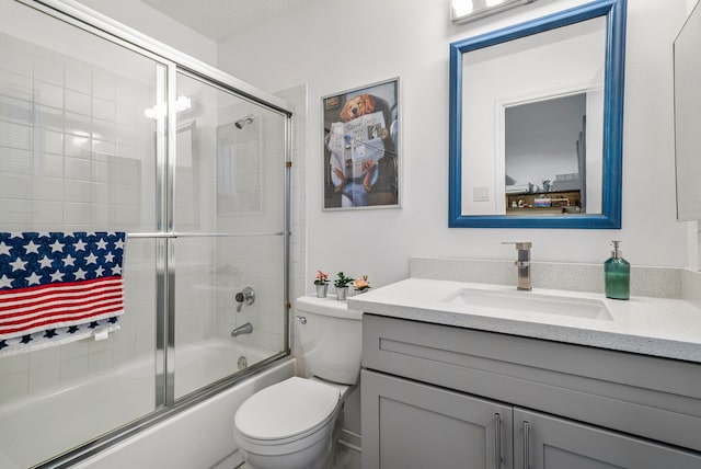 full bathroom with vanity, a textured ceiling, toilet, and combined bath / shower with glass door