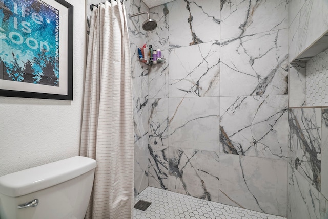 bathroom with a shower with shower curtain and toilet