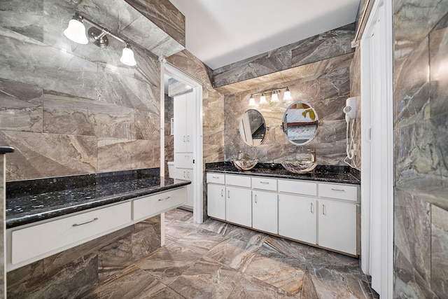 bathroom featuring vanity and tile walls