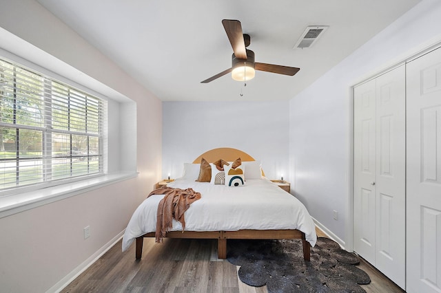 bedroom with dark hardwood / wood-style flooring, a closet, and ceiling fan