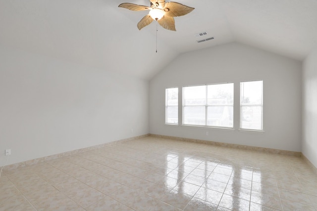 empty room featuring ceiling fan, light tile patterned flooring, and lofted ceiling