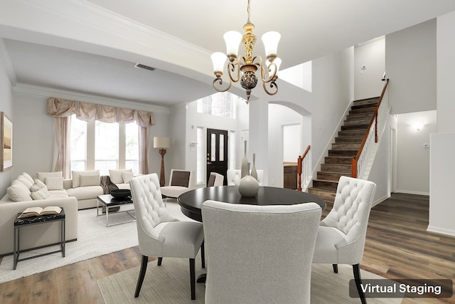 dining room with hardwood / wood-style floors, a notable chandelier, and ornamental molding