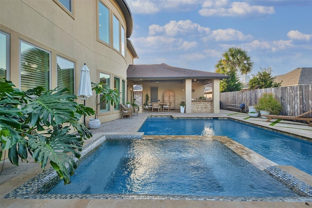 view of swimming pool featuring a patio area and an in ground hot tub