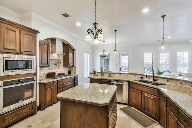 kitchen featuring wall chimney exhaust hood, stainless steel appliances, sink, a notable chandelier, and hanging light fixtures