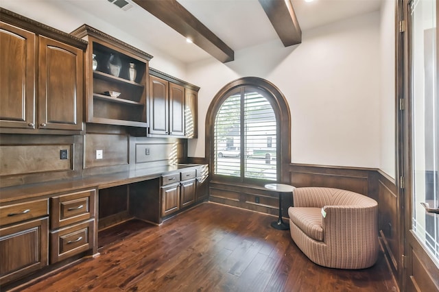 office area with beamed ceiling, built in desk, dark wood-type flooring, and wooden walls