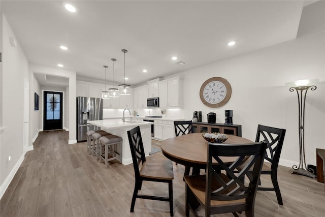 dining room featuring light wood-type flooring and sink