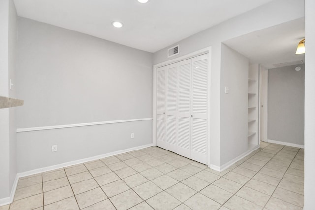 unfurnished bedroom with light tile patterned floors and a closet