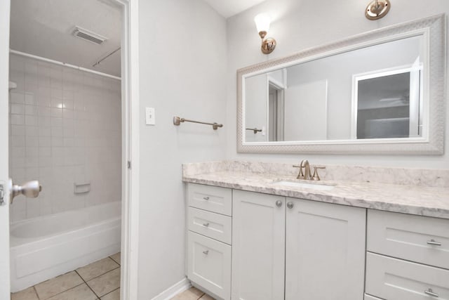 bathroom with tile patterned floors, tiled shower / bath combo, and vanity