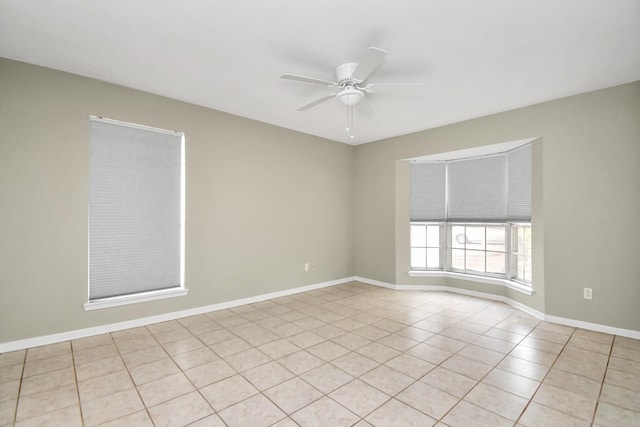 tiled empty room featuring ceiling fan