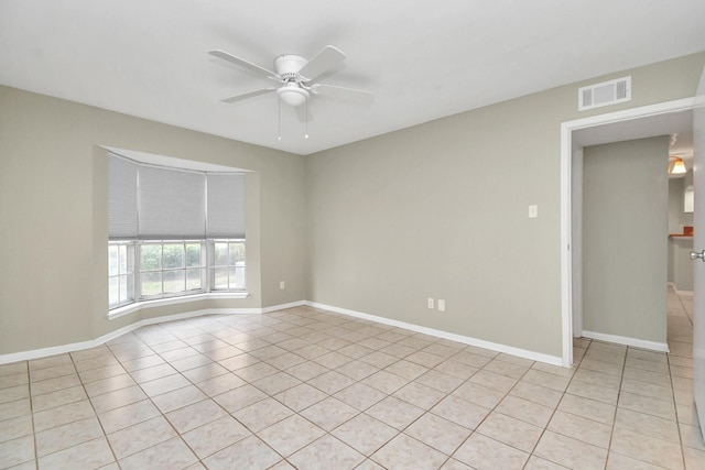 tiled spare room featuring ceiling fan