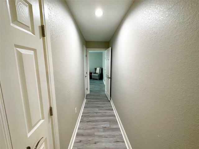 corridor with light hardwood / wood-style flooring