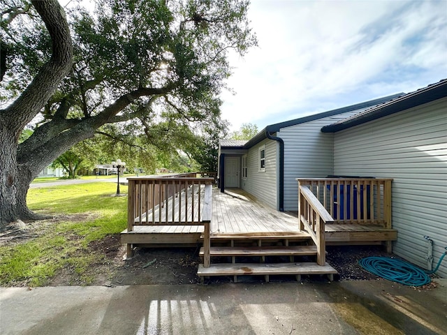 wooden terrace featuring a yard