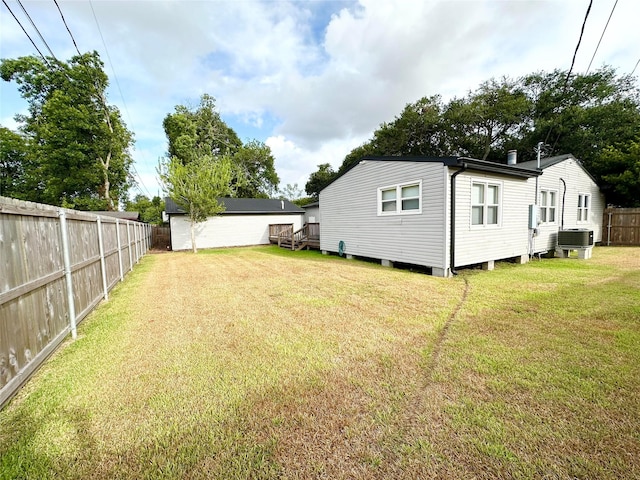 view of yard featuring central AC and a deck