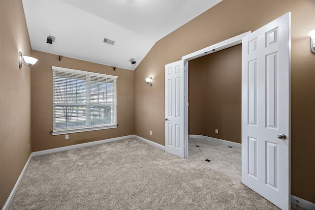 unfurnished bedroom featuring light carpet and vaulted ceiling