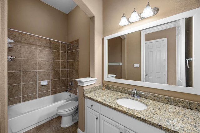 full bathroom with tile patterned floors, vanity, tiled shower / bath combo, and toilet