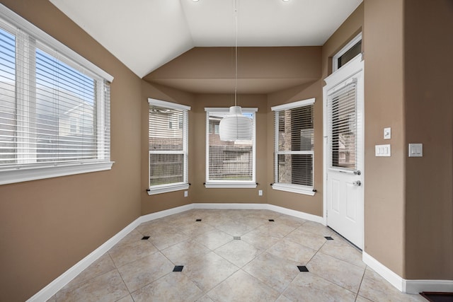 unfurnished dining area with light tile patterned floors and vaulted ceiling