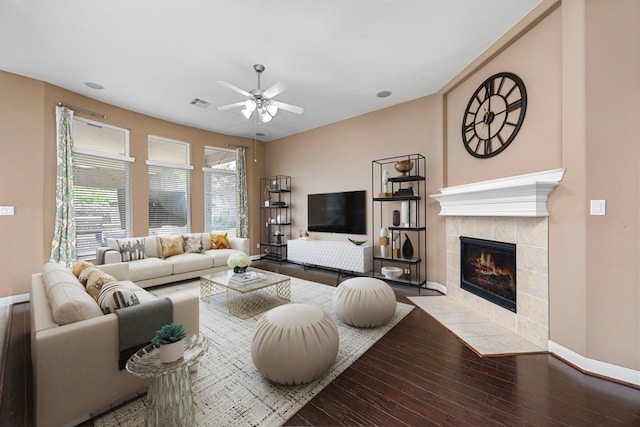 living room featuring ceiling fan, wood-type flooring, and a fireplace