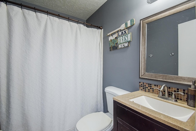 bathroom with backsplash, vanity, toilet, and a textured ceiling