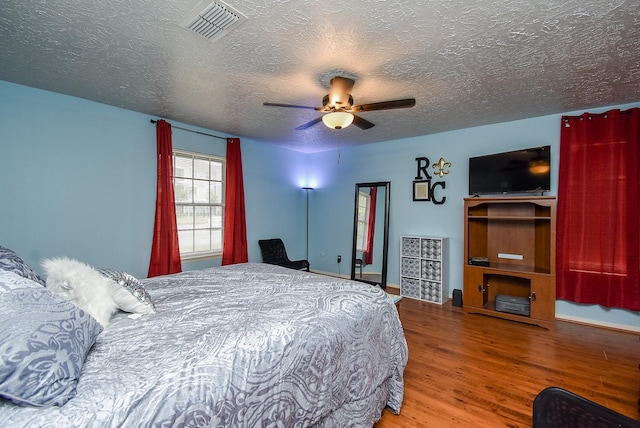 bedroom featuring wood-type flooring, a textured ceiling, and ceiling fan