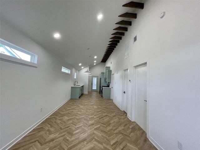 hall featuring beam ceiling, sink, light parquet floors, and high vaulted ceiling