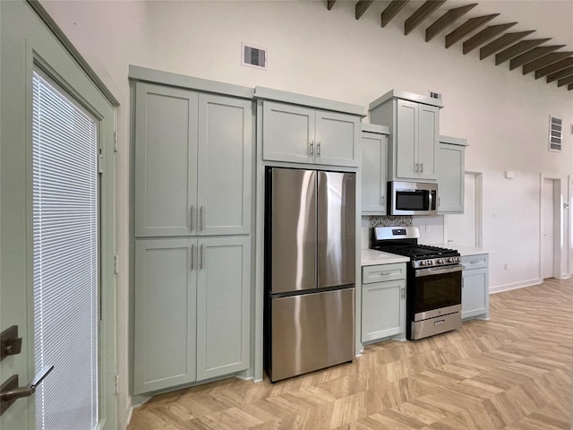 kitchen with backsplash, gray cabinets, and stainless steel appliances