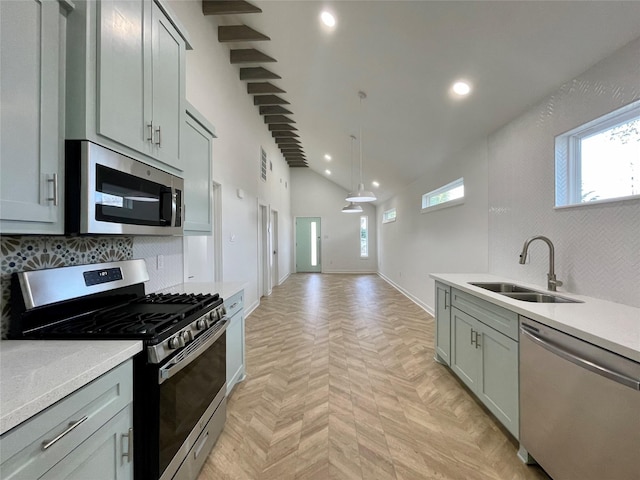 kitchen with a wealth of natural light, sink, hanging light fixtures, and appliances with stainless steel finishes