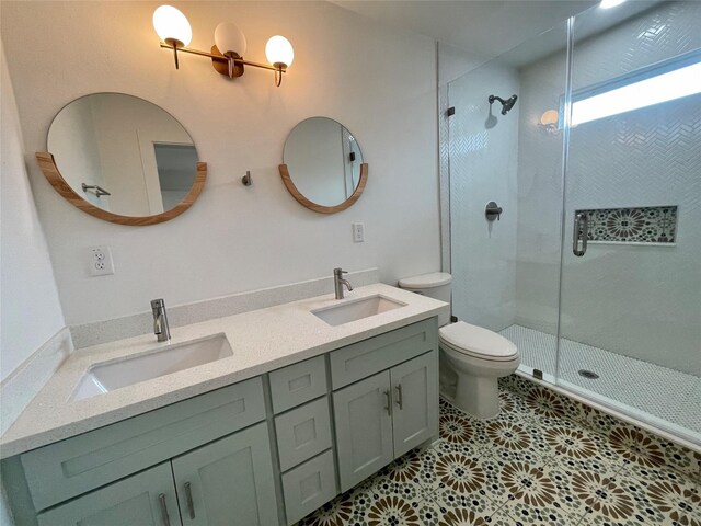 bathroom with tile patterned floors, a shower with door, vanity, and toilet