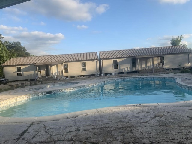 view of swimming pool featuring a jacuzzi