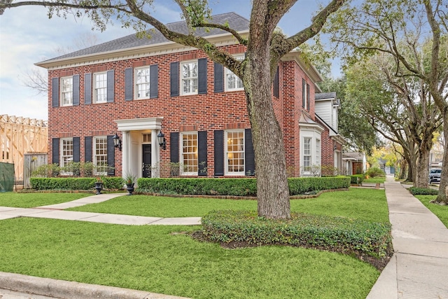 colonial inspired home featuring a front lawn