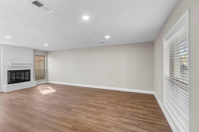 unfurnished living room featuring wood-type flooring and a fireplace