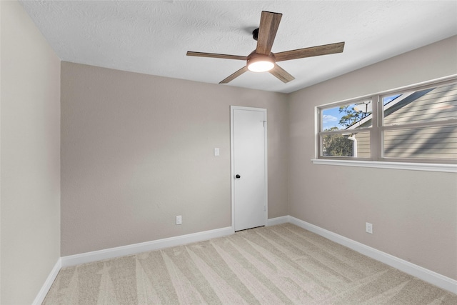 carpeted empty room with ceiling fan and a textured ceiling