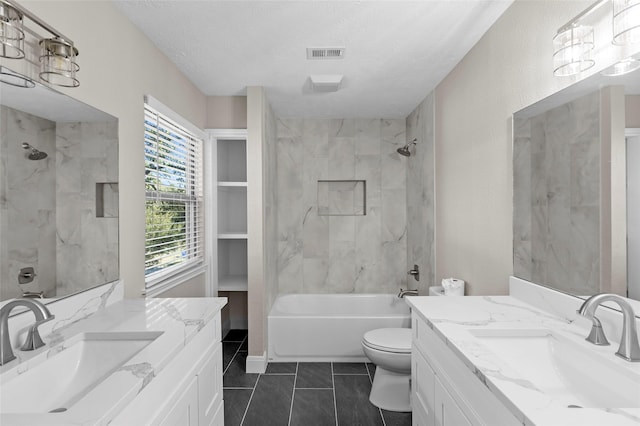 full bathroom with tile patterned floors, vanity, a textured ceiling, and tiled shower / bath