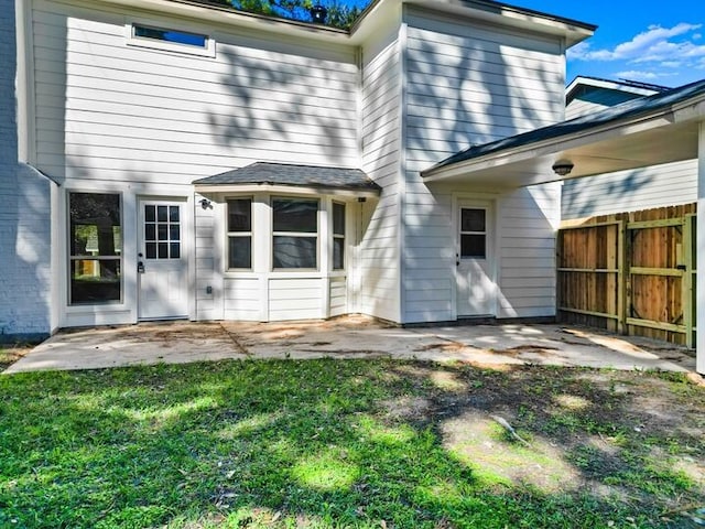 back of house with a patio area and a lawn