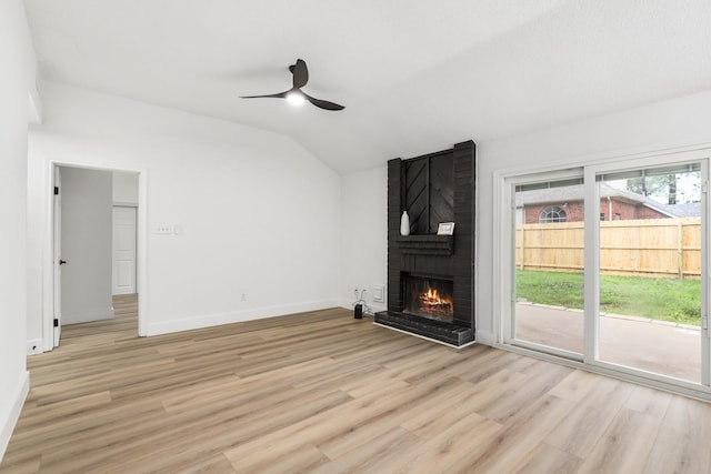 unfurnished living room with ceiling fan, light hardwood / wood-style floors, lofted ceiling, and a fireplace