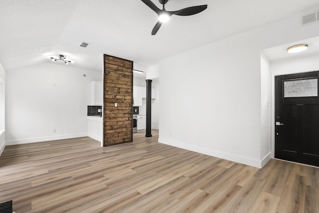 unfurnished living room featuring ceiling fan, vaulted ceiling, and light wood-type flooring