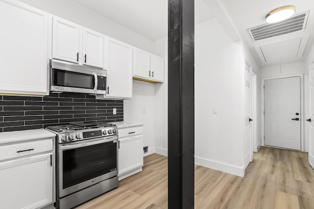 kitchen featuring white cabinetry, appliances with stainless steel finishes, and light hardwood / wood-style flooring