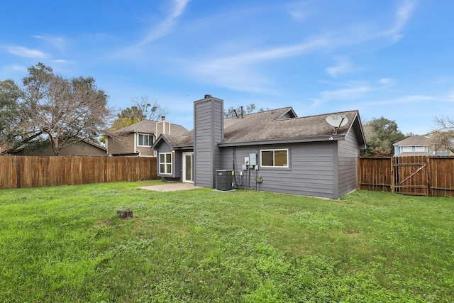 rear view of house featuring a lawn and central air condition unit