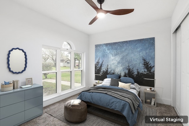 carpeted bedroom with ceiling fan and a closet