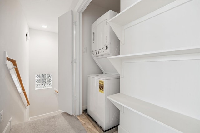 laundry room with stacked washer / drying machine and light tile patterned floors