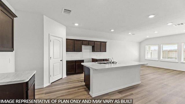 kitchen featuring dark brown cabinetry, a center island with sink, light hardwood / wood-style flooring, and sink