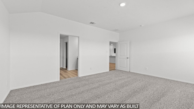 carpeted empty room with vaulted ceiling