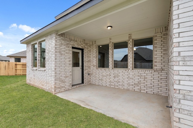 doorway to property featuring a lawn and a patio area