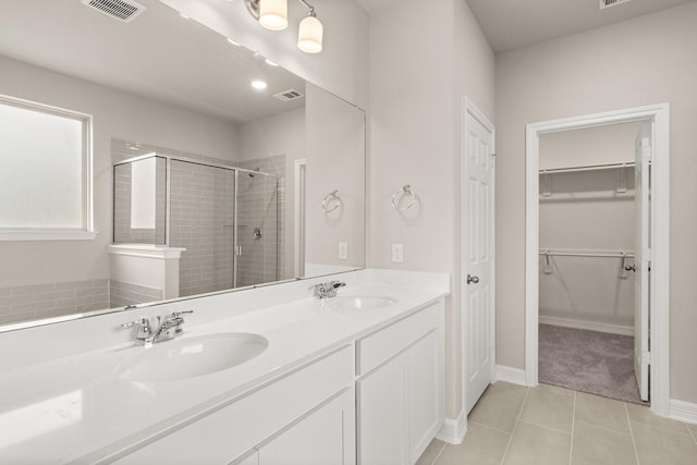 bathroom featuring tile patterned flooring, vanity, and a shower with door