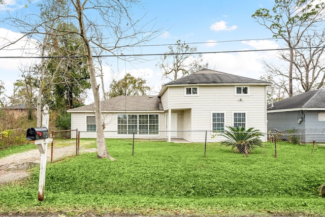 rear view of house featuring a yard