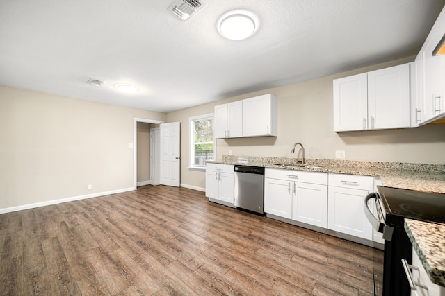 kitchen with dishwasher, stove, sink, light stone counters, and white cabinetry