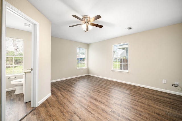 unfurnished room featuring ceiling fan, dark hardwood / wood-style flooring, and a wealth of natural light