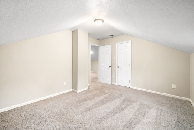 bonus room featuring a textured ceiling, carpet floors, and vaulted ceiling