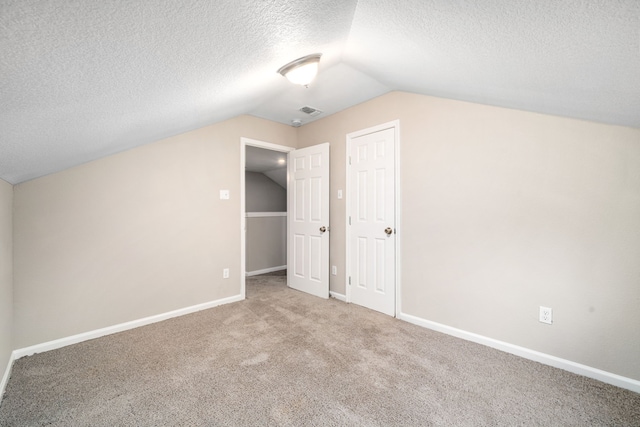 bonus room with a textured ceiling, carpet floors, and lofted ceiling