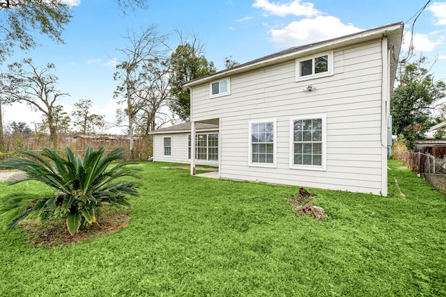 rear view of property featuring a lawn