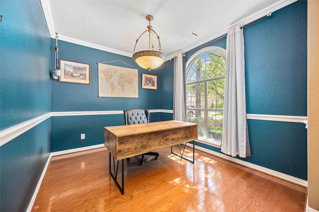 office area featuring wood-type flooring, a wealth of natural light, and ornamental molding